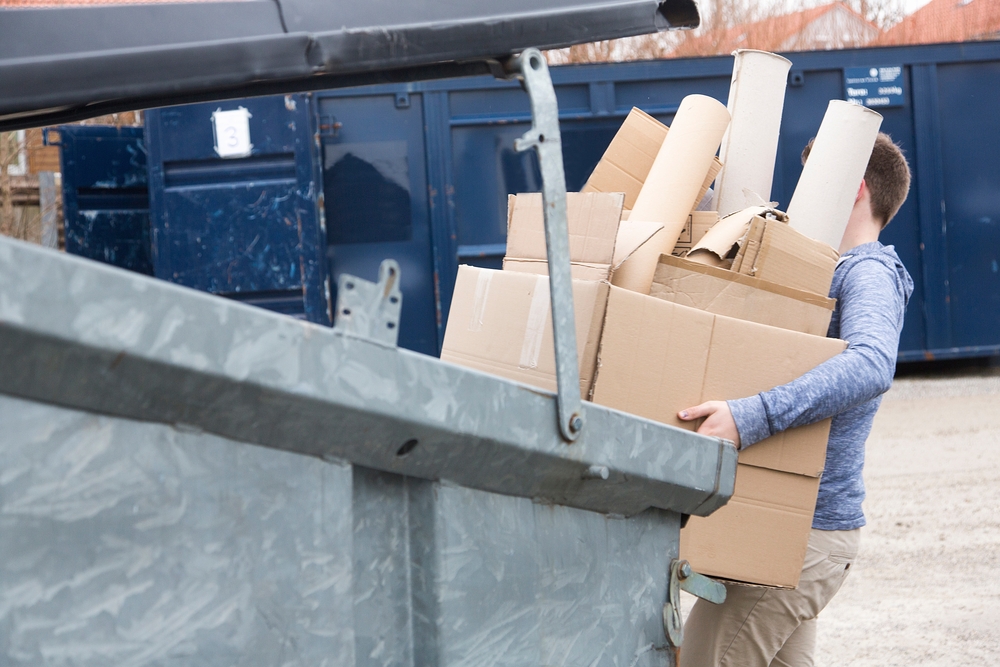 Homme portant des cartons en déchèterie